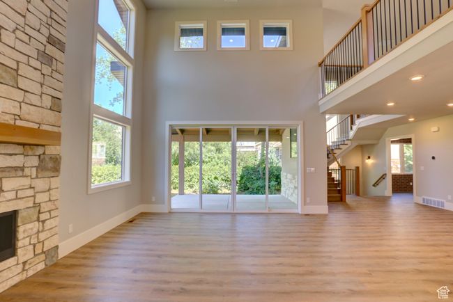 Unfurnished living room with a high ceiling, wood finished floors, stairway, and recessed lighting | Image 16