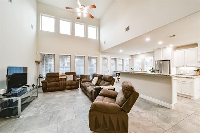 Secondary view of the family room showcase the expansive windows that frame the large covered patio and spacious backyard. | Image 10