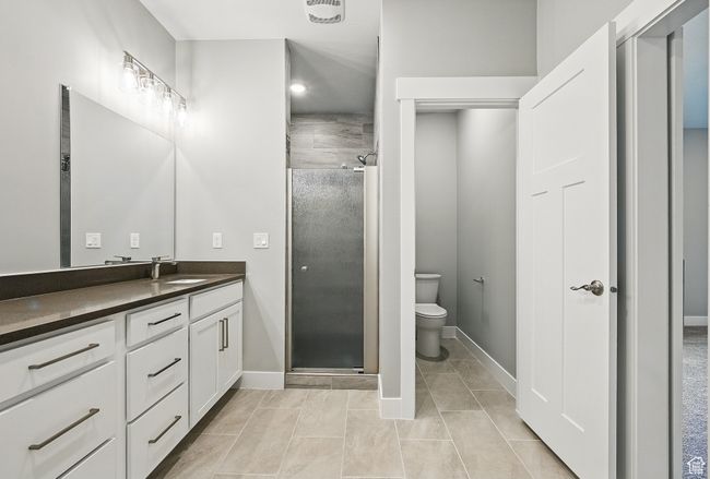 Bathroom with vanity, a shower stall, toilet, baseboards, and tile patterned floors | Image 29