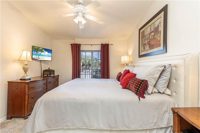 Bedroom featuring light carpet, baseboards, vaulted ceiling, and a ceiling fan | Image 15