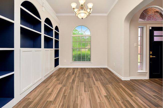 Exquisitely custom-built cabinets located in this flex room - perfect for hosting family meals or to be used as Office | Image 12