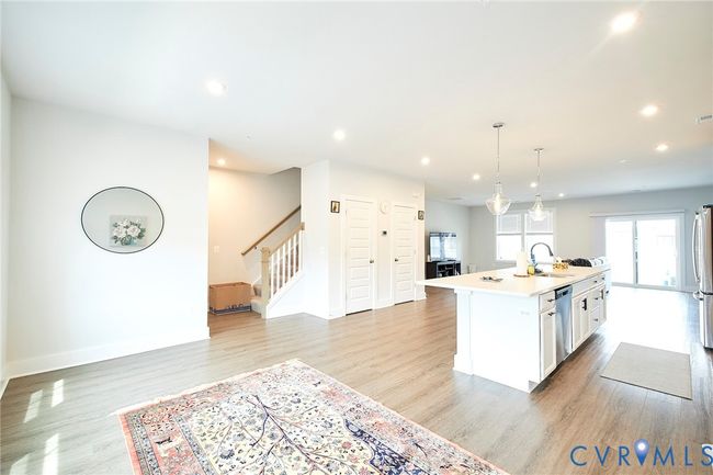 Kitchen featuring an island with sink, white cabinets, light countertops, recessed lighting, and light wood-style floors | Image 44