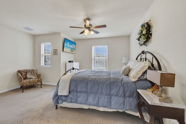 Bedroom with visible vents, baseboards, carpet flooring, and ceiling fan | Image 28