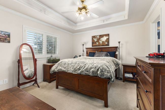 Bedroom with ceiling fan, ornamental molding and raised ceiling | Image 26