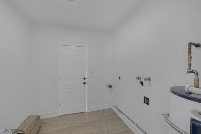 Laundry room with water heater, light wood-style flooring, and hookup for a washing machine | Image 28