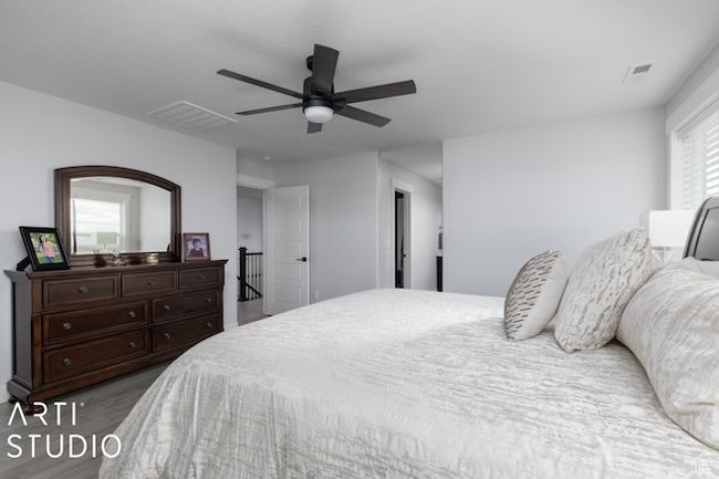 Bedroom with visible vents, wood finished floors, and a ceiling fan | Image 32