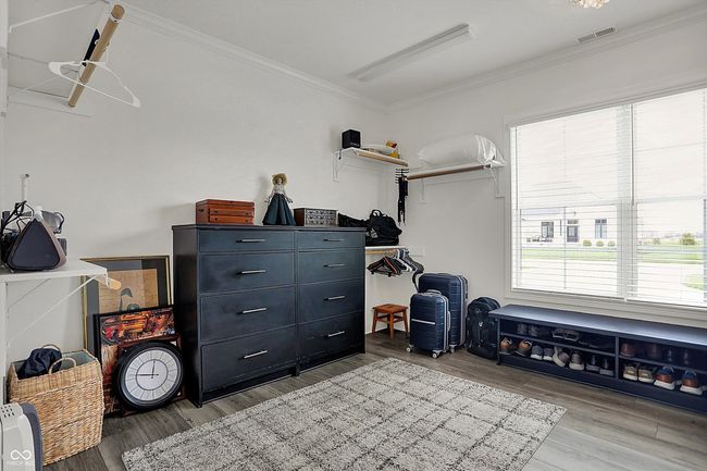 interior space featuring wood finished floors, visible vents, and ornamental molding | Image 31