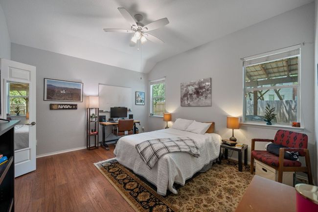 Bedroom with a desk, wood finished floors, lofted ceiling, baseboards, and a ceiling fan | Image 15