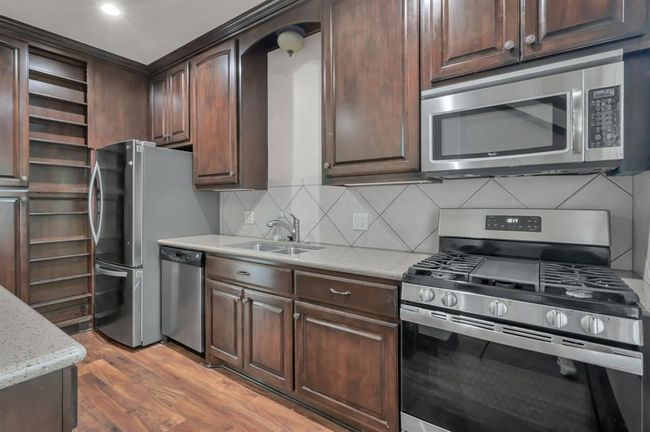 Kitchen complete with gas Range, Microwave, Dishwasher, and Refrigerator. | Image 44