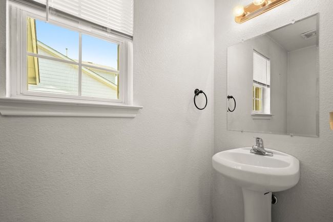 First level half bath with a healthy amount of natural light. | Image 12