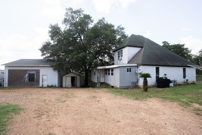 Back of property with a shingled roof and dirt driveway | Image 22