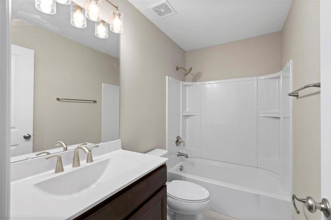 Full bathroom featuring vanity, bathtub / shower combination, and toilet | Image 19