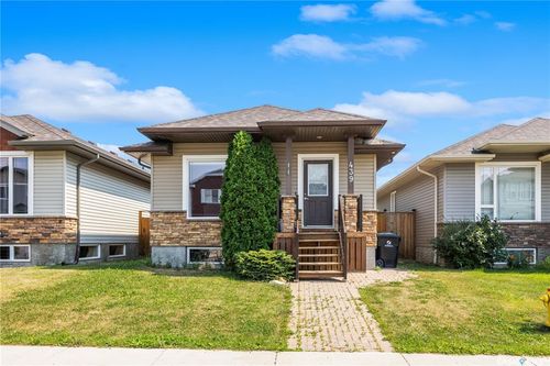 Charming raised bungalow showcasing a welcoming brick and siding exterior, anchored by a columned front entrance and wooden deck with multiple steps | Card Image