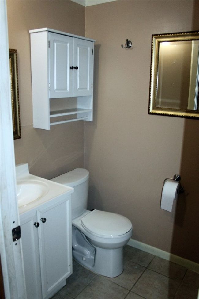 Bathroom featuring toilet, tile patterned flooring, vanity, and baseboards | Image 19