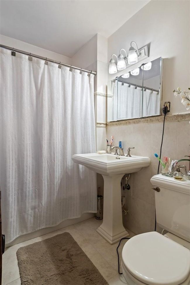 Bathroom with tile walls, backsplash, toilet, and tile patterned floors | Image 15