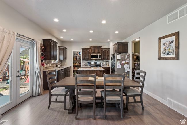 Dining room with dark wood-style floors, baseboards, visible vents, and recessed lighting | Image 5