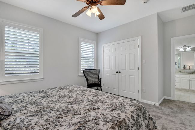 Bedroom with light colored carpet, a closet, ceiling fan, and ensuite bathroom | Image 26