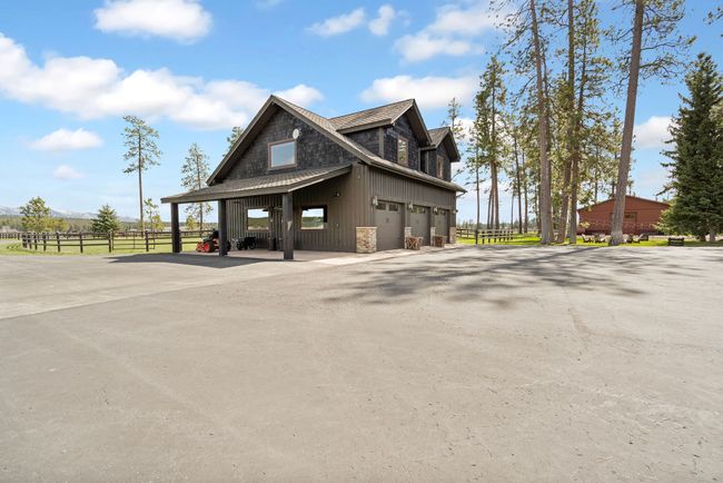 View of home's exterior with a garage, driveway, and fence | Image 67