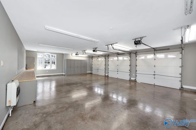 gas heat, finished concrete, wooden cabinets for storage, walk in door to side yard and one door enters kitchen of home | Image 41