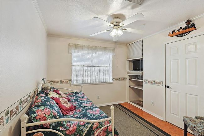 Charming third bedroom with built-in shelving for added function, storage, and character — a versatile space for family, guests, or a home office. | Image 18