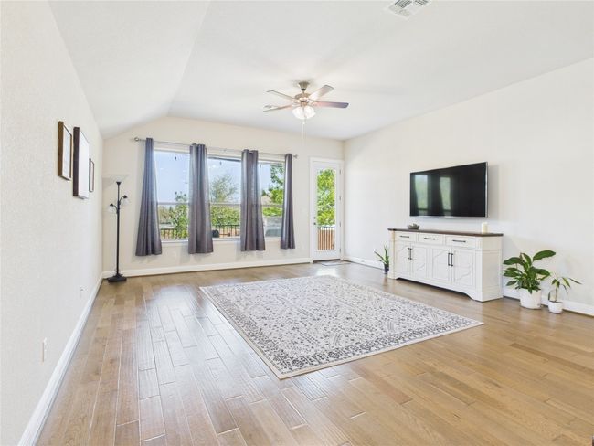 Unfurnished living room featuring a ceiling fan, vaulted ceiling, light wood finished floors, and visible vents | Image 8