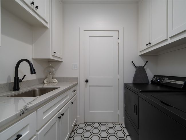 Laundry room with independent washer and dryer, cabinet space, and light tile patterned floors | Image 22