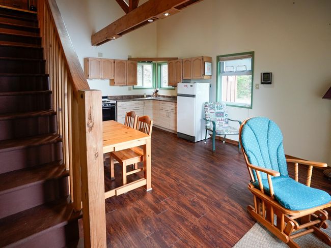 Kitchen featuring dark countertops, high vaulted ceiling, freestanding refrigerator, dark wood-style floors, and range with gas cooktop | Image 10