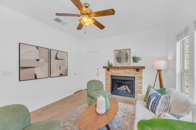 Living area with a ceiling fan, a fireplace, and wood finished floors | Image 5