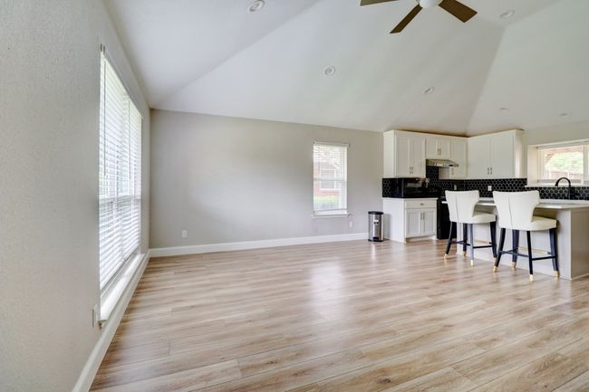 Living area featuring ceiling fan, high vaulted ceiling, and light wood finished floors | Image 8