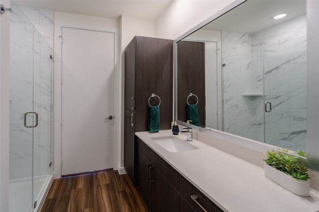 Bathroom featuring vanity, wood finished floors, and a marble finish shower | Image 6
