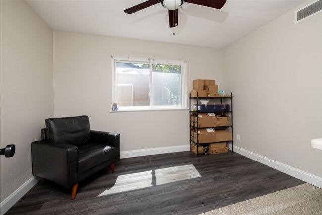 Living area featuring visible vents, baseboards, a ceiling fan, and wood finished floors | Image 32
