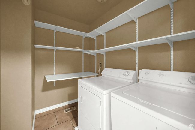 Washroom featuring washing machine and clothes dryer and light tile patterned floors | Image 21