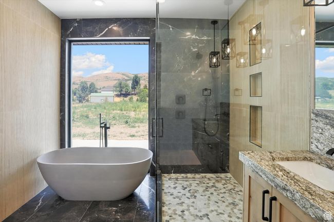 Full bathroom with tile walls, a soaking tub, a shower stall, vanity, and marble finish flooring | Image 31
