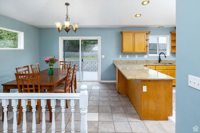 Kitchen with pendant lighting, light stone counters, a chandelier, light tile patterned flooring, and sink | Image 10