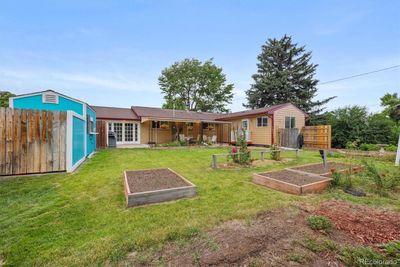 Lush backyard with a strawberry patch, butterfly garden, grape vines, lilacs, an abundance of flowers and raised gardens. | Image 2