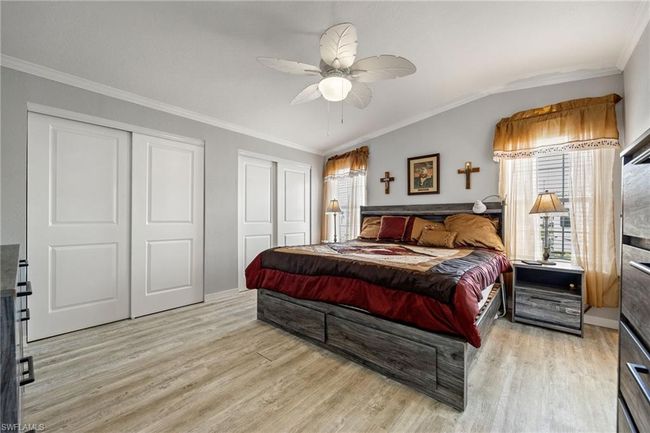 Bedroom featuring light wood-style floors, multiple closets, and crown molding | Image 23