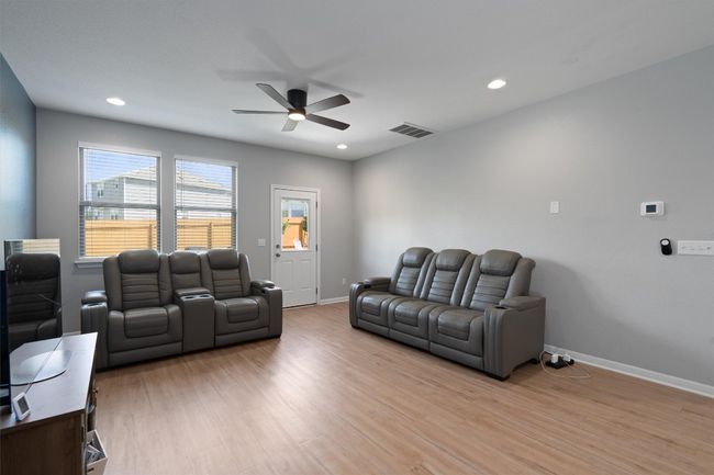 Living area with a ceiling fan, light wood finished floors, recessed lighting, and an office area | Image 8