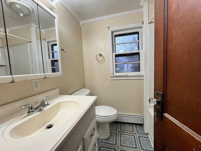 Full bathroom with vanity, shower combination, toilet, ornamental molding, and baseboard heating | Image 19