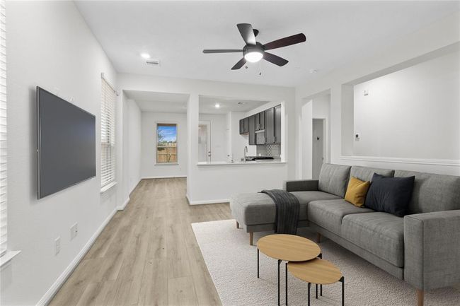 This light and bright spacious family room is the perfect layout for entertaining or just relaxing. Whether it's simply a night in or entertaining family and friends, this home has ample open space for everyone to enjoy! Featuring gorgeous vinyl plank flooring, large windows with blinds, high ceilings with ceiling fan, and wonderful access to your gorgeous kitchen | Image 4