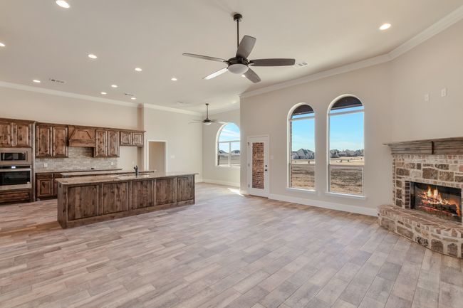 Kitchen featuring stainless steel appliances, open floor plan, a ceiling fan, a center island with sink, and recessed lighting | Image 5