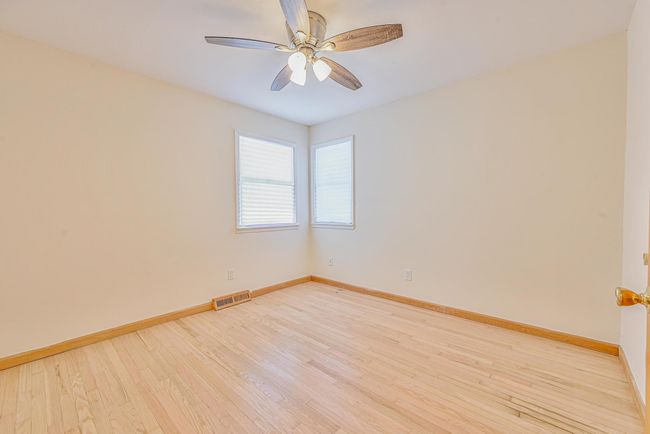 Empty room with wood finished floors and a ceiling fan | Image 10