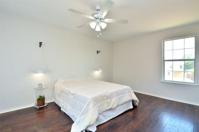 Bedroom with baseboards, hardwood / wood-style floors, and ceiling fan | Image 11
