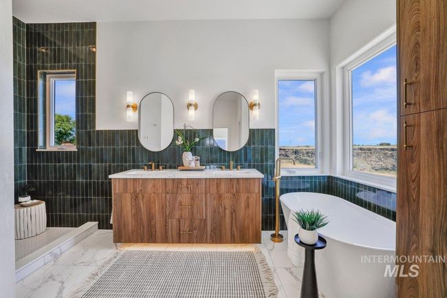 Full bath featuring tile walls, marble finish floors, a freestanding bath, double vanity, and a walk in shower | Image 23