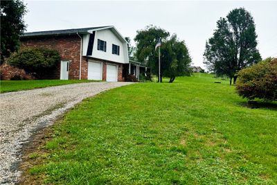 View of property exterior with a lawn and a garage | Image 3