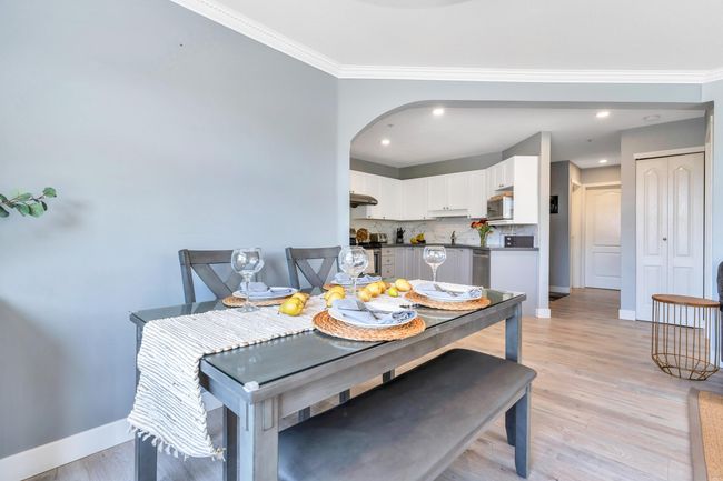 Dining space with light wood-type flooring, crown molding, and baseboards | Image 11
