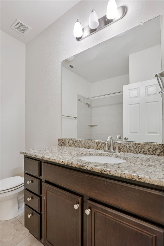 Bathroom featuring walk in shower, visible vents, vanity, and toilet | Image 24