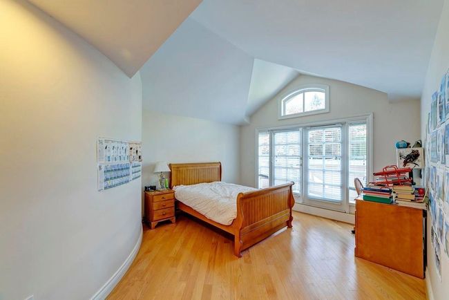 Bedroom featuring light wood-type flooring, vaulted ceiling, and baseboards | Image 6