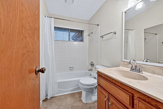 Bathroom with shower / bathtub combination with curtain, vanity, and a textured ceiling | Image 15