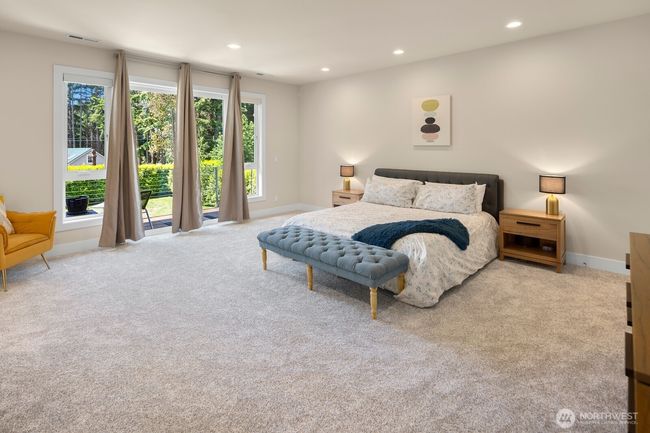 Upstairs, the sumptuous primary suite is sized for even the largest furniture, and the private deck overlooks the greenery outside. | Image 14