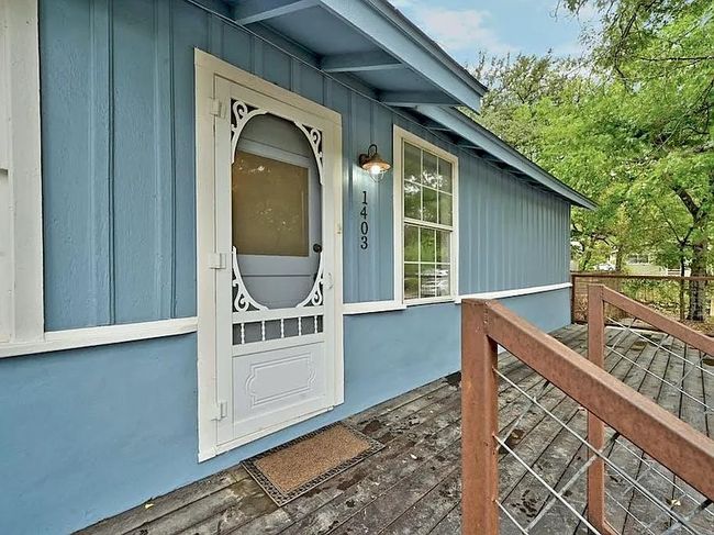 Property entrance with board and batten siding and a wooden deck | Image 18